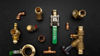 Assorted brass and copper plumbing fittings arranged on surface, distributor product selection display