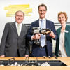 Schnelles Verpressen eines Rohrverbinders von Viega: Ministerpräsident Hendrik Wüst (M.) mit Walter Viegener, Vorsitzender des Viega Gesellschafterausschusses, und Dr. Sandra Bell, Mitglied der Viega Geschäftsführung. (Foto: Viega)