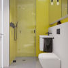 Individuell geplante Tiny Houses gehen auch beim Badezimmer auf die Wünsche der Kunden ein. Dreh- und Angelpunkt ist hier die bodengleiche Dusche, deren Fläche multifunktional genutzt werden kann. Die Trendfarbe Schwarz bringt in Verbindung mit sonnengelben Mosaikfliesen Leben in das Bad. (Foto: Viega)