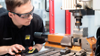 Young man operating drill during apprentice program