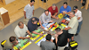 Group in plumbing training class using tools and fittings at workshop, distributor education session