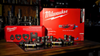 Milwaukee® M12™ FORCE LOGIC® press tool giveaway prize package featuring press tool, IPS-P press rings, Viega MegaPress fittings, and accessories displayed on a workbench.