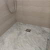  The natural stone shower bases are fitted with Viega Advantix floor drains with stainless steel grates.