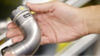 Hand holding Viega press fitting elbow on pipe, plumbing parts for distributor inventory management