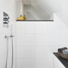 Unter der Dachschräge bietet eine bodengleiche Dusche ausreichend Platz und den nötigen Komfort. Die geflieste Bank ist nicht nur im Alter eine wertvolle Hilfe bei der täglichen Hygiene. (Foto: Viega)