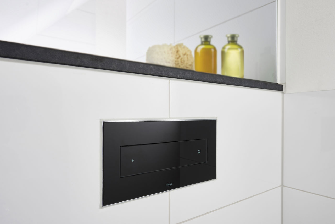 Dank des fliesenbündigen Einbaus verschmilzt die hochwertig gestaltete WC-Betätigungsplatte von Viega fast zu einer Einheit mit der Fliesenwand. (Foto: Viega)